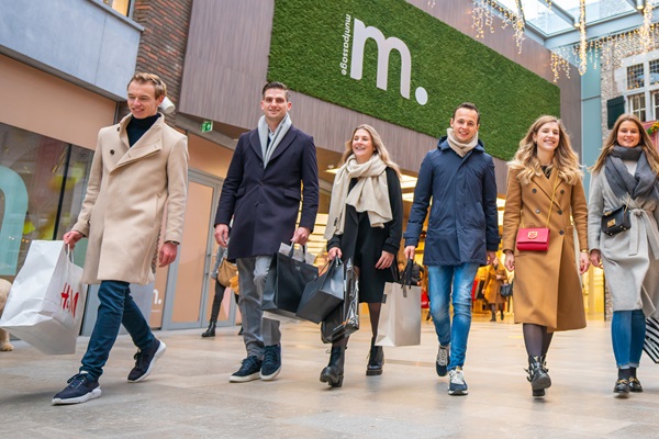 Groep jongeren met shoppingtassen wandelt door de Muntpassage in Weert